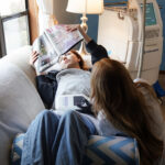 Accent Skin Tightening performed on stomach of Laser & Wellness Center patient as she lays on a couch reading a magazine.